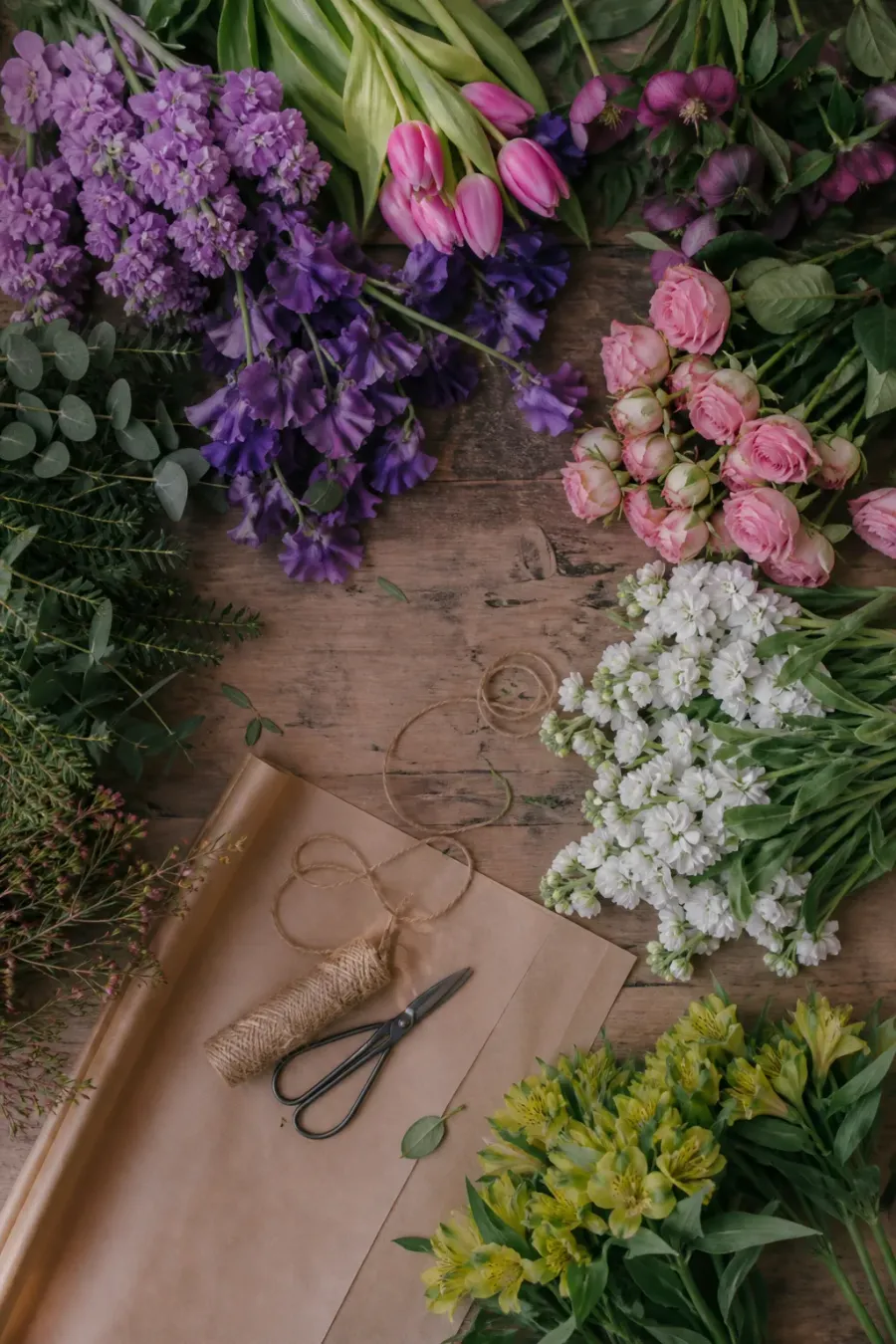Flores ordenadas por color sobre una mesa de florería